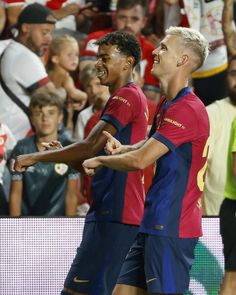 two soccer players are congratulating each other in front of an arena full of people