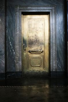 an old door is in the middle of a room with marble walls and flooring