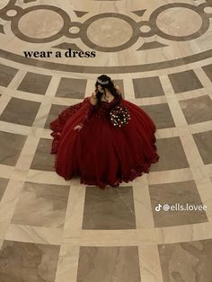 a woman in a red dress is sitting on the floor with her hands behind her head