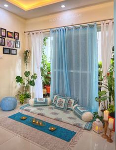 a living room filled with lots of furniture and plants in front of a large window