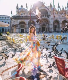 a woman in a long dress surrounded by birds