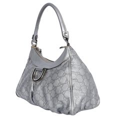 Authentic, pre-owned Gucci Abbey D Ring Shoulder Bag in Silver. Features silver large GG logo print with embossed leather, silver hardware, D-ring front logo, zipper top closure, off-white textile interior lining with zipper slip pocket and patch pocket, rolled leather handle strap. Add your wallet, keys, phone, cosmetic bag, and more. You're going to love this Gucci! Authenticity code: 190525 491403 Made in Italy Strap Drop: 7" Textile Interior, Gg Logo, Gold Ounce, Zipper Top, Leather Silver, D Ring, Handbag Backpack, Silver Hardware, Leather Handle