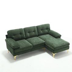 a green sectional couch sitting on top of a white floor