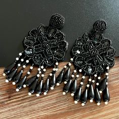 Bohemian Vibes Earrings- Ethically handcrafted, these Floral Black Beaded bohemian-style earrings feature intricate embroidery and dazzling beadwork. Designed with fine detailing, they are the perfect accessory to complement any outfit for any occasion. Specifications and Dimensions Colour: Black and White Total Length: 4 inches Width: 2 inches Closure: Push-back secured Weight: Very lightweight Materials: Beads and Fabric  Style Tip Pair these earrings with a flowy maxi dress or a casual chic o Beaded Earrings Black, Bohemian Vibes, Dangler Earrings, Boho Handmade, Flowy Maxi Dress, Intricate Embroidery, Casual Chic Outfit, Earrings Black, Trendy Gift