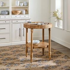 a wooden table sitting on top of a rug in a kitchen