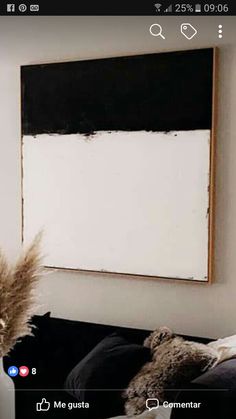 a black and white painting hanging on the wall next to a bed in a bedroom