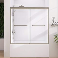 a white bathroom with a glass shower door and shelves on the wall next to it