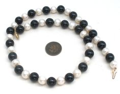 Fine Gemstone Jewelry - This is a classic necklace with polished black onyx beads and genuine pearls. The beads are 10mm (.38") wide, 18" long, clasp is hallmarked 14K. Classic Onyx Round Bead Jewelry, Classic Onyx Round Beads Jewelry, Classic Single Strand Onyx Jewelry, Black Single Strand Pearl Necklace, Classic Black Single Strand Jewelry, Classic Black Beaded Necklaces, Classic Single Strand Onyx Necklace, Classic Onyx Single Strand Necklace, Classic Black Single Strand Pearl Necklace