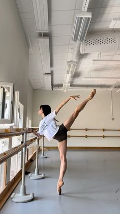 a young ballerina is practicing her moves in the ballet studio