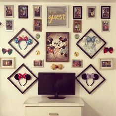 there is a television on the dresser in front of mickey mouse head magnets and pictures