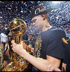 a man holding up a trophy surrounded by confetti