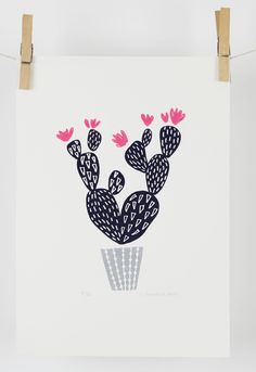 a white poster hanging on a clothes line with pink flowers in the shape of cacti