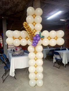 a large balloon cross with grapes on it in an indoor setting for a party or celebration