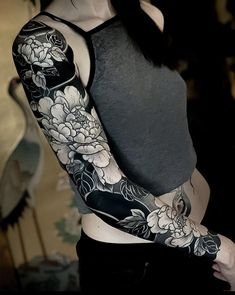 a woman with black and white flowers on her arm