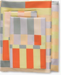 three different colored squares are folded on top of each other, one in orange and the other in grey