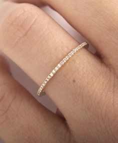 a woman's hand with a wedding band on it, and the ring is in gold