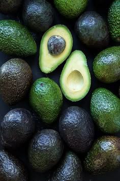 an avocado is cut in half and placed on top of other fruit pieces