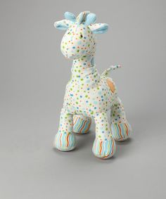 a giraffe toy sitting on top of a gray surface