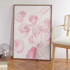 a pink and white painting sitting on top of a wooden floor next to a chair