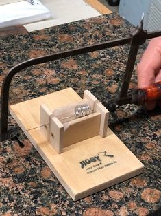 a person is working on a piece of wood that has been made into a mouse trap