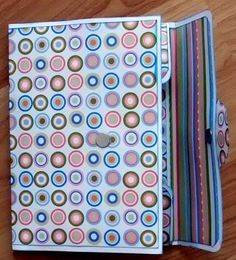 an open book with colorful circles on it sitting on a wooden table next to a cell phone