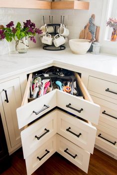 an open drawer in the corner of a kitchen