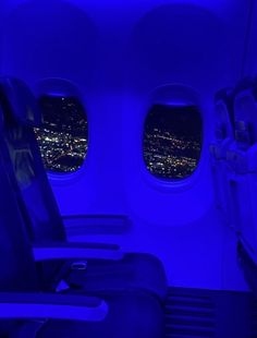 the inside of an airplane with blue lights on it's windows and seat covers