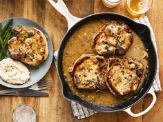 some meat and gravy in a skillet on top of a wooden table