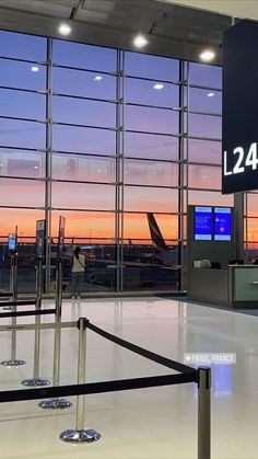 an airport terminal with the sun setting in the background