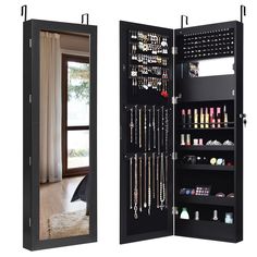 an open black jewelry cabinet with mirrors on the doors and shelves in front of it