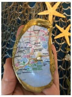 a person holding up a piece of gold foil with a map on it