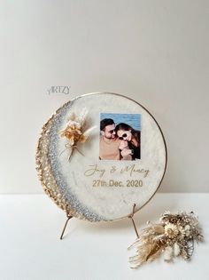 a personalized photo is placed on a wooden slice with a small flower in front of it