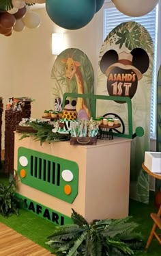 a safari themed birthday party with balloons and decorations on the wall, including an animal truck