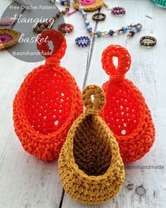 two crocheted baskets sitting on top of a white wooden table next to beads