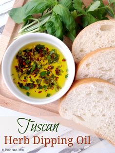 there is a bowl of oil and some bread on the table with herbs in it