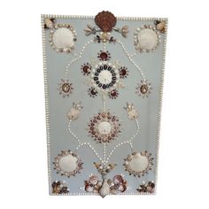 a decorative wall hanging with seashells and pearls