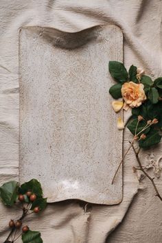 a white tray with flowers and leaves on it