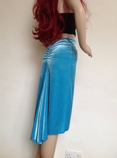 Pencil cut skirt made in blue stretch velvet with sparkle. The back of the skirt is fuller and longer and swishes around on the dance floor. There is back gathering under the waistband. The fabric is medium weight and good for holding shape.  Measurements  Waist 66-74 Hips 82-92 Length Flowy Draped Maxi Skirt For Parties, Ruched Flowy Skirt For Party, Relaxed Draped Skirt For Party, Party Draped Skirt With Lining, Blue Asymmetrical Maxi Skirt For Party, Pleated Draped Skirt For Party, Fitted Gathered Skirt For Costume Party, Draped Pleated Skirt For Party, Draped Lined Skirt For Party