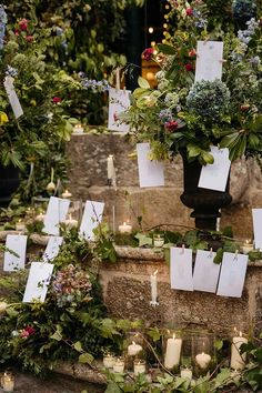 flowers and candles are placed on the steps in front of an outdoor wedding venue with note cards attached to them