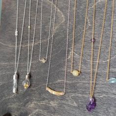 several different necklaces hanging on a table