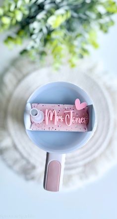 a close up of a toothbrush holder with flowers in the background