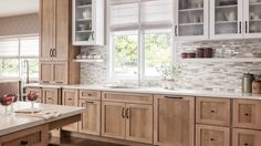 a kitchen filled with lots of wooden cabinets and counter top space next to a window