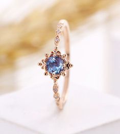 a gold ring with a blue stone in the center