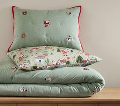 pillows stacked on top of each other in front of a wooden dresser with christmas decorations