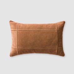 a brown sued pillow on a gray background