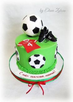 a green cake with soccer balls on top