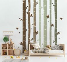 a child's bedroom with wall decals that have trees and birds on them