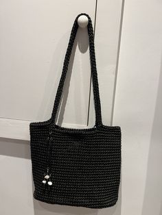 a black handbag hanging on a white door