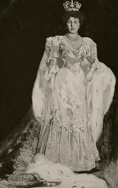 an old photo of a woman in a gown and tiara with her hands on her hips