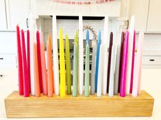 there are many different colored candles in the holder